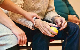 An elderly gentleman holding an exercise ball