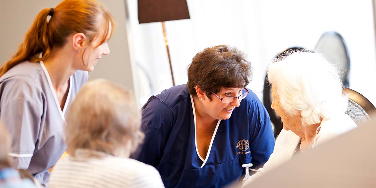 Residents and carers chatting in a bright room