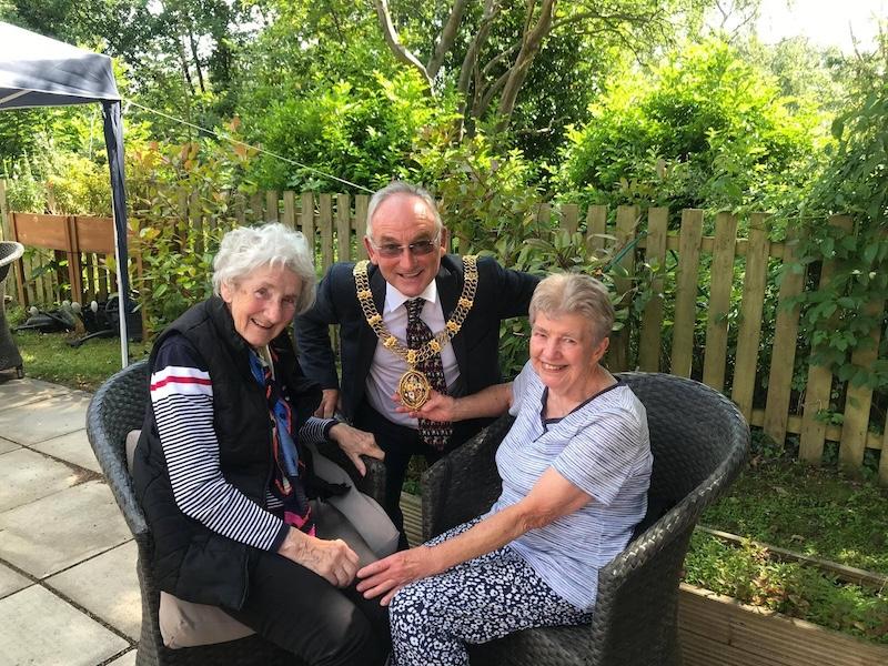 two residents sat in the garden with the mayor