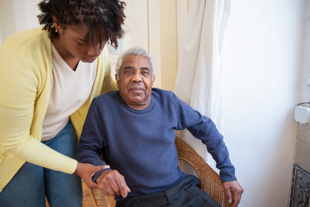 resident getting helped out of chair by carer