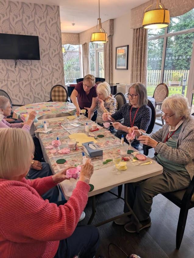 residents sat at a table doing arts and crafts