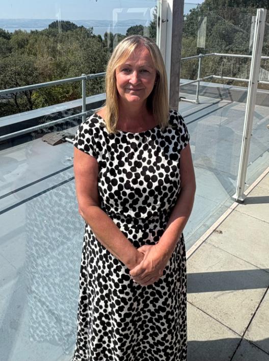 lady in a black and white dress posing for a staff photo