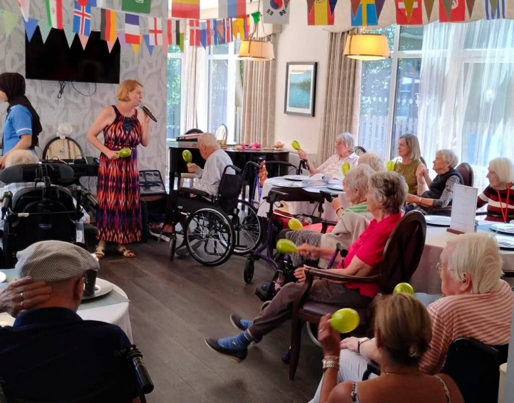 a lady with a microphone singing to care home residents