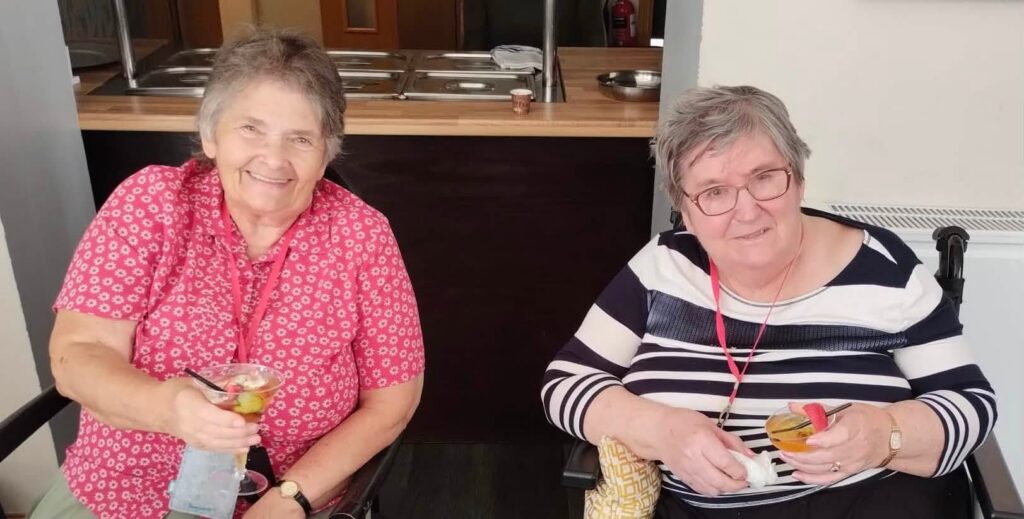 two older ladies sat holding glasses