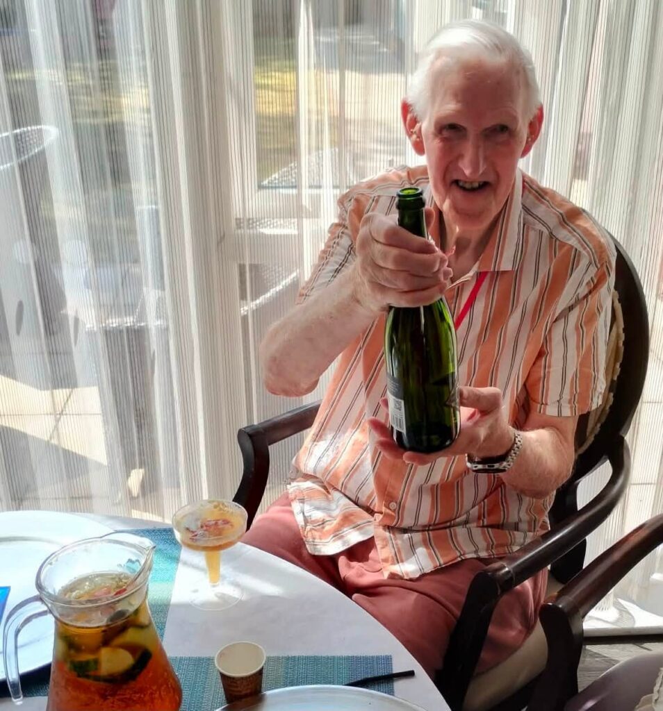 an older man holding a bottle
